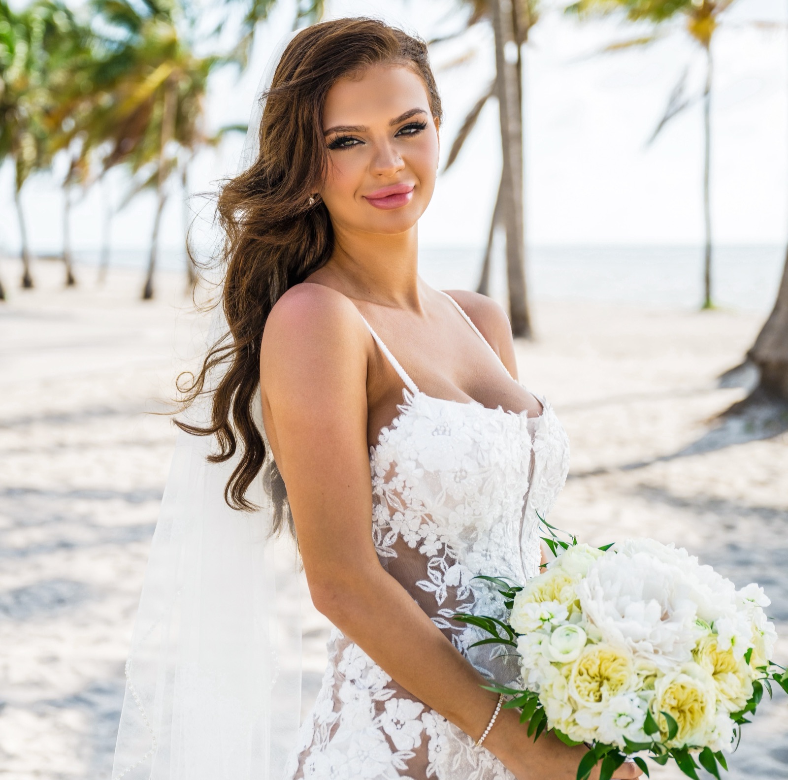 Bride with bouquet glowing with a custom spray tan under Miami palms